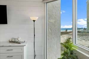 a floor lamp in a room with a view of the beach at Top of the Gulf 410 - Beach Front Resort Condo - RENOVATED LIKE NEW in Panama City Beach