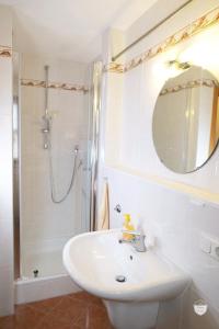 a white bathroom with a sink and a shower at FeWo Schönwetter in Weßling +25 photos