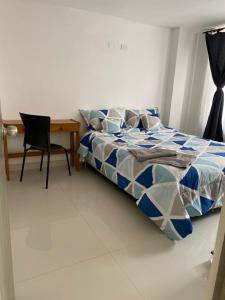 1 dormitorio con cama, escritorio y silla en Tunja Magic Habitación., en Tunja