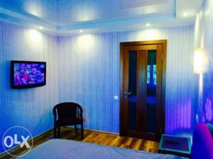a bedroom with a bed and a tv on a wall at VIP apartment in Cherkasy