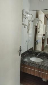 a bathroom with a sink and a mirror at Lacqua diromaa com fogão, geladeira, micro-ondas, Park aquático 24h, acomoda até 5 pessoas in Caldas Novas
