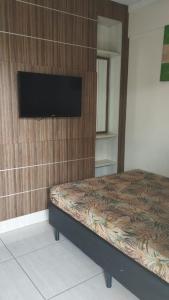 a bedroom with a bed and a flat screen tv at Lacqua diromaa com fogão, geladeira, micro-ondas, Park aquático 24h, acomoda até 5 pessoas in Caldas Novas
