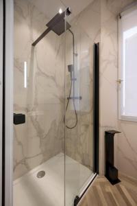 een douche met een glazen deur in de badkamer bij Le 34 in Saint-Tropez