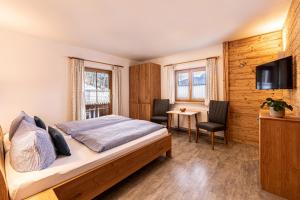 Schlafzimmer mit einem Bett, einem Schreibtisch und einem TV in der Unterkunft Haus Vogl in Berchtesgaden