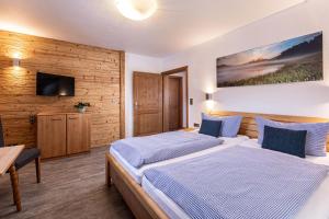 a hotel room with two beds and a tv at Haus Vogl in Berchtesgaden