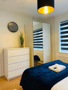 een slaapkamer met een bed, een dressoir en een spiegel bij Modern and Comfy 5 Bed Home, Wi-FI, Free Parking! in Cambridge