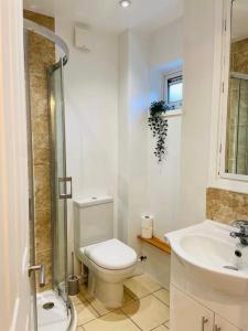 Baño blanco con aseo y lavamanos en Modern and Comfy 5 Bed Home, Wi-FI, Free Parking! en Cambridge