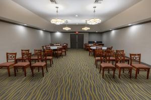 a dining room with tables and chairs and lights at Red Roof Inn & Suites Irving - DFW Airport South in Irving