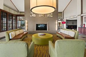 a lobby with chairs and a table and a fireplace at Red Roof Inn & Suites Irving - DFW Airport South in Irving