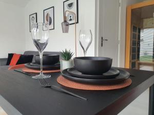 una mesa con dos copas de vino y una mesa con platos en Stunning 1 King bed cabin in Grays, en Grays