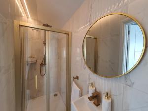 een badkamer met een douche, een wastafel en een spiegel bij Stunning 1 King bed cabin in Grays in Grays Thurrock