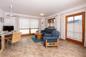 a living room with a blue couch and a desk at Ferienwohnung Vogl in Berchtesgaden