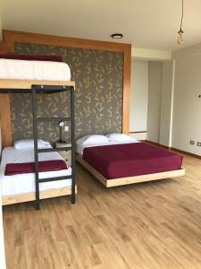 Dama Suites & Spa في سيينيغيلا: سريرين بطابقين في غرفة مع أرضيات خشبية
