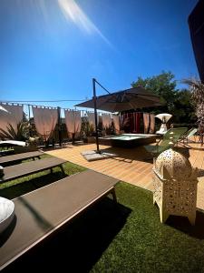 un patio con mesa, sombrilla y sillas en WELCOME TRAVELLER FRIDA'S ROOMs, en Caprino Veronese