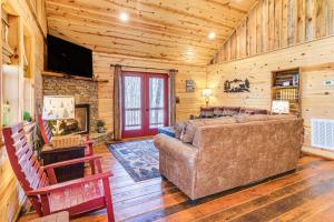 a living room with a couch and a fireplace at Dog-Friendly Cabin with Fire Pit and Hot Tub! in Murphy