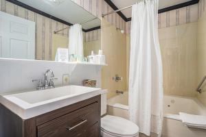 een badkamer met een wastafel, een toilet en een bad bij Harbor House Inn in Grand Haven