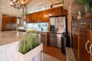 a kitchen with wooden cabinets and a stainless steel refrigerator at Casa da Torre in Vieira do Minho