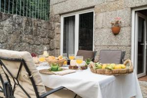 a table with baskets of fruit and glasses of orange juice at Casa da Torre in Vieira do Minho +6 photos