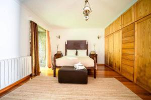 a bedroom with a bed and a ottoman at Casa da Torre in Vieira do Minho