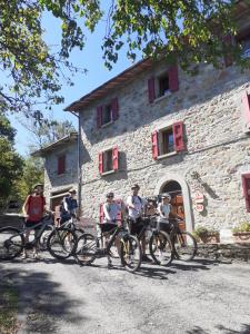 a group of people on bikes in front of a stone building at Agri B&B Ca' Gennara in Porretta Terme