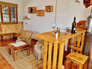 een keuken met een houten tafel en een fles wijn bij Loft rural in Granada