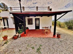 een klein huis met een rood dak en een tafel bij Loft rural in Granada