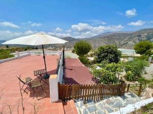 een patio met een bank en een parasol bij Loft rural in Granada +2 foto's