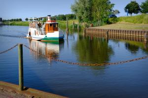 a boat is docked on the water next to a dock at Neu seit 2023 FeWo No 3 Friesenhuus Carolinensiel in Carolinensiel