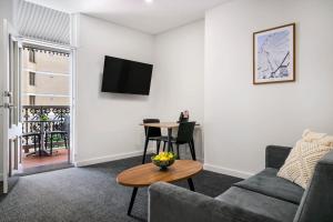 a living room with a couch and a table at Durham Serviced Apartments in Adelaide