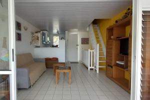 a living room with a couch and a table at Appartement Coconut in Saint-François +20 photos