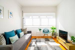 een woonkamer met een bank en een tv bij LAZ apartment in Porto