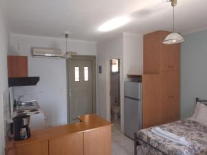 a room with a bed and a kitchen with a desk at Reggina's place in Kefallonia