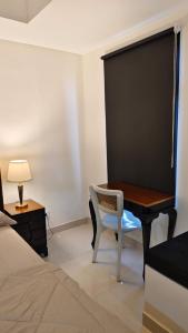 1 dormitorio con escritorio y 1 cama en BAGUSROOM CHADSTONEPOLLUX, en Kedungg
