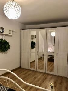 Pokój z białymi szafkami i żyrandolem w obiekcie Marilyn w mieście Kostrzyn nad Odrą