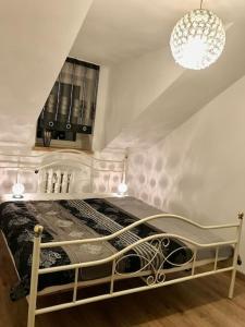 a bed in a room with a chandelier at Marilyn in Kostrzyn nad Odrą