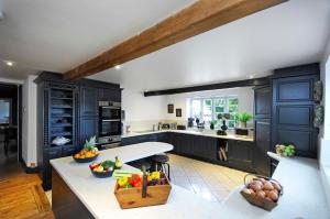 a kitchen with blue cabinets and fruits on the counter at Warren Farm Farmhouse nr Oxford in Culham