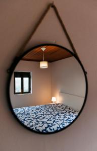a mirror reflecting a bed in a room at Casa da Laurinha in Arcos de Valdevez