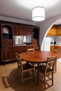 a kitchen with a wooden table and chairs at Casa da Laurinha in Arcos de Valdevez