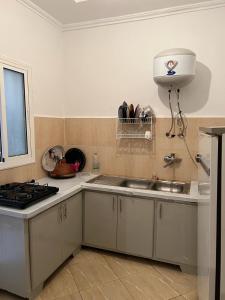 uma cozinha com um lavatório e um fogão em appartements meublée nr 1 en rez-de-chaussée em Oujda