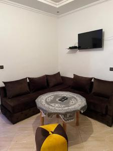 uma sala de estar com um sofá e uma mesa em appartements meublée nr 1 en rez-de-chaussée em Oujda