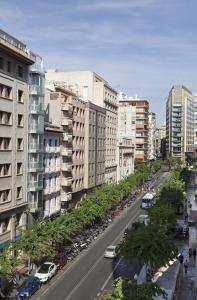 ruchliwa ulica miejska z samochodami i budynkami w obiekcie Apartamentos Boni w Alicante