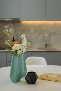 een groene vaas met witte bloemen op een tafel bij LAZ apartment in Porto +38 foto's