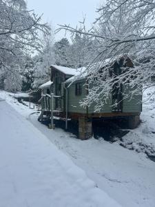 dom pokryty śniegiem obok drogi pokrytej śniegiem w obiekcie Lower batter farm w mieście Huddersfield