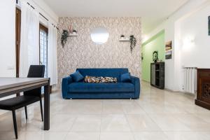 un divano blu in soggiorno con tavolo di Lotus - Apartment sul mare con giardino a Lido di Ostia