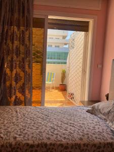 1 dormitorio con cama y vistas a un balcón en Tanger City, en Tánger