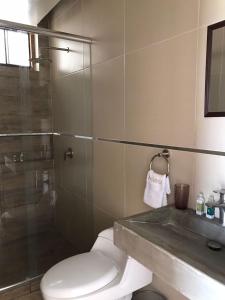 a bathroom with a toilet and a glass shower at Dama Suites & Spa in Cieneguilla