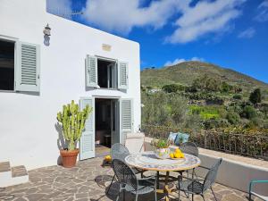 a white house with a patio with a table and chairs at Villa Margot in Lipari