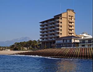 a large building next to a beach with water at Hakusen in Yonago