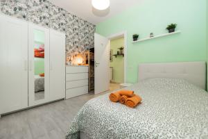 a bedroom with a bed with an orange towel on it at Lotus - Appartamento sul Mare a Ostia con Giardino Relax in Lido di Ostia