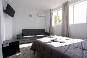 ein Schlafzimmer mit einem Bett und einem Sofa in der Unterkunft Liberal Gazi in Athen